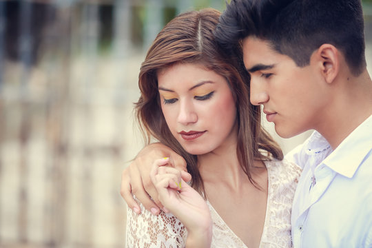 Beautiful sensual portrait of young stylish passionate couple hugging in summer park outdoors. Portrait of hispanic couple outside