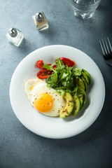 Fried egg with avocado and green salad