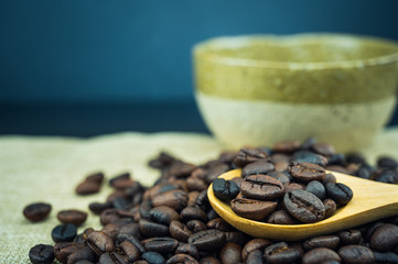 Roasted coffee beans in a wooden spoon.