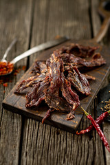 Dried beef meat on wooden board with spices chili pepper leaf cuisine