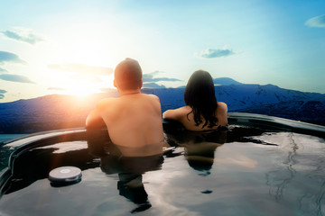 Asian couples in a hot tub or onsen of luxurious and natural villas Travel in Iceland, holiday,...