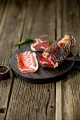 Dried beef meat on wooden board pepper knife spoon wooden texture cuisine