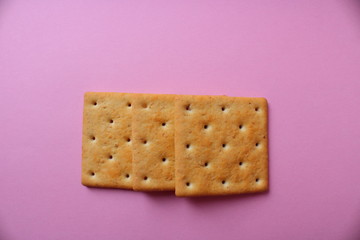 three crackers on a pink house background