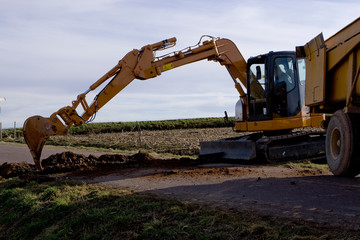 Chantier et pose d'une canalisation par un agriculteur dans un champ