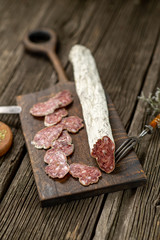 Dried sausage on wooden board with spices chili pepper wooden texture cuisine