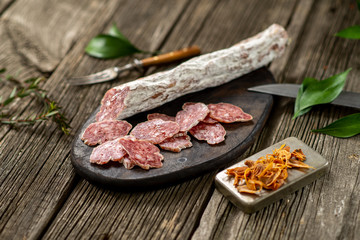 Dried sausage on wooden board with spices chili pepper wooden texture cuisine
