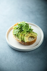 Homemade healthy avocado toast with fresh arugula