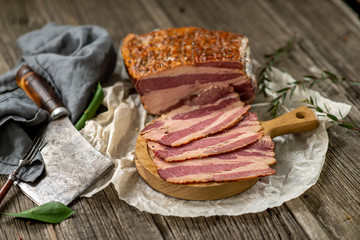 salted smoked bacon on paper with kitchen towel hatchet leaves cuisine cooking wooden texture