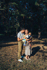 Portrait of a funny family having good time outdoors. Adventure, travel, tourism, lifestyle concept. Spending time together each weekends. Time for family. Parents and one year old son. Hard light