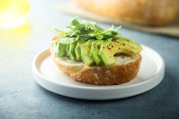 Homemade healthy avocado toast with fresh arugula