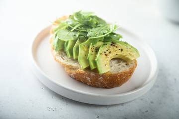 Homemade healthy avocado toast with fresh arugula