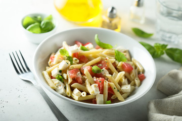 Pasta salad with tomato, mozzarella and basil