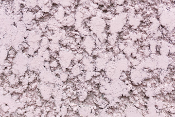 Pink wall, plaster under a fur coat. Relief porous wall surface widespread in USSR. Texture, background or backdrop.
