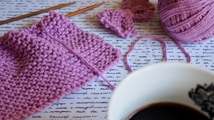 Obraz na płótnie Canvas Knitting needles pink yarn and coffee 