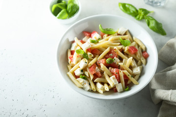 Pasta salad with tomato, mozzarella and basil
