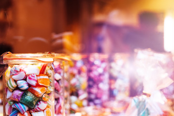 Naklejka na ściany i meble Blur background of delicious sweet beautiful fantasy colourful jar box of candy treat for summer holiday kids gift souvenir. Eat too much bonbon lollipop sugar is toxic unhealthy nutrition addiction