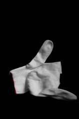 Glove made of white fabric on a black background. International signs and symbols. Youth symbols....
