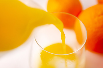 pours orange juice into a glass close up selective focus