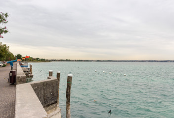 Fototapeta premium View of Lake Garda from the promenade of the Sirmione town in Lombardy, northern Italy