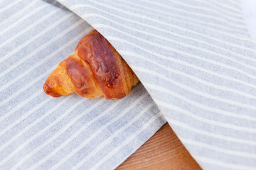 Homemade croissant wrapped in a stripey linen fabric
