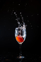 Cherry tomato splash water.  Cherry tomato pouring into glass.