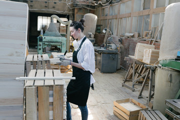 Fototapeta premium Confident woman working as carpenter in her own woodshop