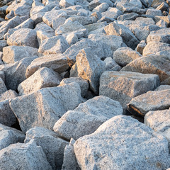 Close up. rock stone breakwater at the pier on the beach.