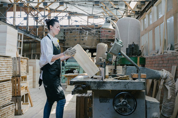 Fototapeta na wymiar Confident woman working as carpenter in her own woodshop