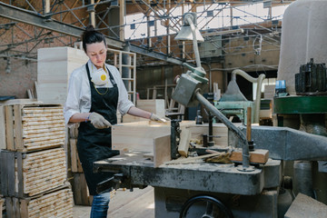 Confident woman working as carpenter in her own woodshop