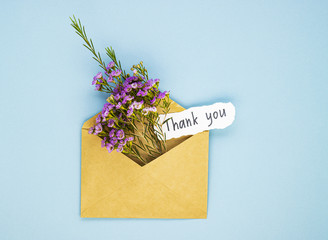a bouquet of spring wildflowers in an envelope and the inscription thank you. the concept of gratitude to medical workers for their work