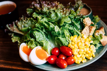Homemade delicious fresh organic local farm salad for breakfast lunch healthy nutrition light meal with vegetables egg, letture, cherry tomato, corn vegetarian recipe serve on wooden table background
