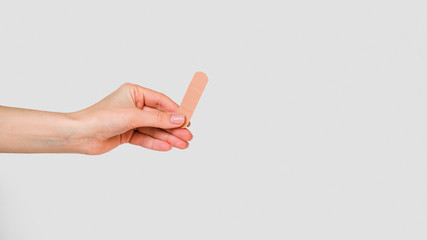 Close-up hand holding band aid