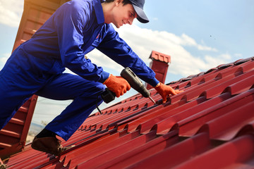 Close up of young happy man contractor worker in blue overalls