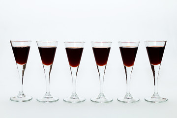 Glasses of red wine on a white table