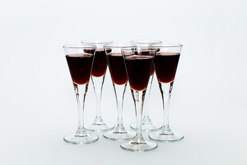 Glasses of red wine on a white table
