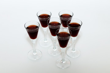 Glasses of red wine on a white table