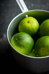 Juicy green limes on the rustic background. Selective focus. Shallow depth of field.