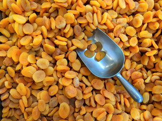 Dried apricots with a large metal spoon / scoop ready to be sold unpackaged to the environmentally...