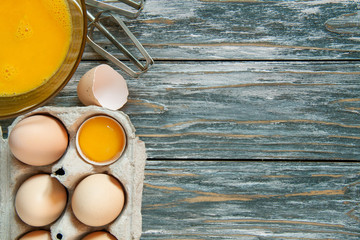 Raw scrambled in a plate on a gray wooden table. For pancakes, omelettes or for breading.