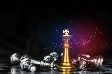golden king surrounded with silver chess pieces on chess board game competition with graphic graph...