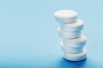 Tower of Medicinal tablets on a blue background, isolated.