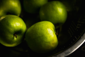 Close-up green apples on the rustic wooden background. Selective focus. Shallow depth of field.