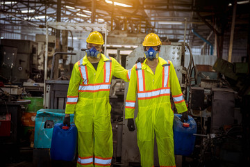 A worker industry wearing safety uniform ,black gloves and gas mask under checking chemical tank in...