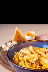 cooked pasta in a plate on a wooden board in the studio