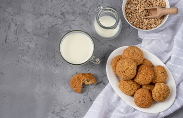 Oatmeal cookies with a cup of milk. On a gray concrete background. View from above.