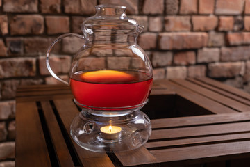 Teapot on a wooden table with a candle heater