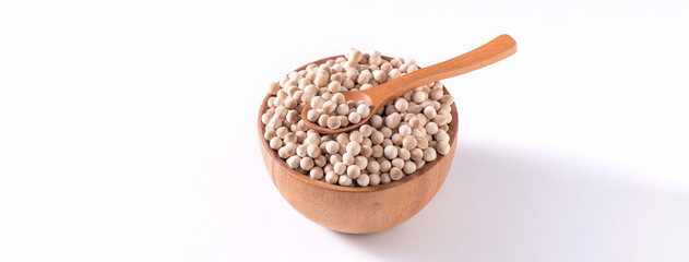 Dry raw brown tapioca pearls in a wooden bowl with spoon isolated on white background, close up, ingredient of making bubble boba milk tea.