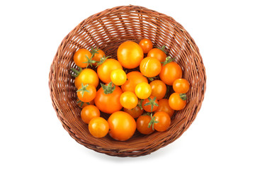 Yellow little tomatoes on wicker plate