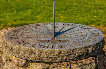 Sun clock with green class summer time  sundial clock old with shadow