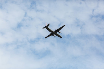 Fototapeta na wymiar A beautiful view of a flying passenger wide-body airliner, an airplane, against a background of white clouds in a blue summer sky. selective focus